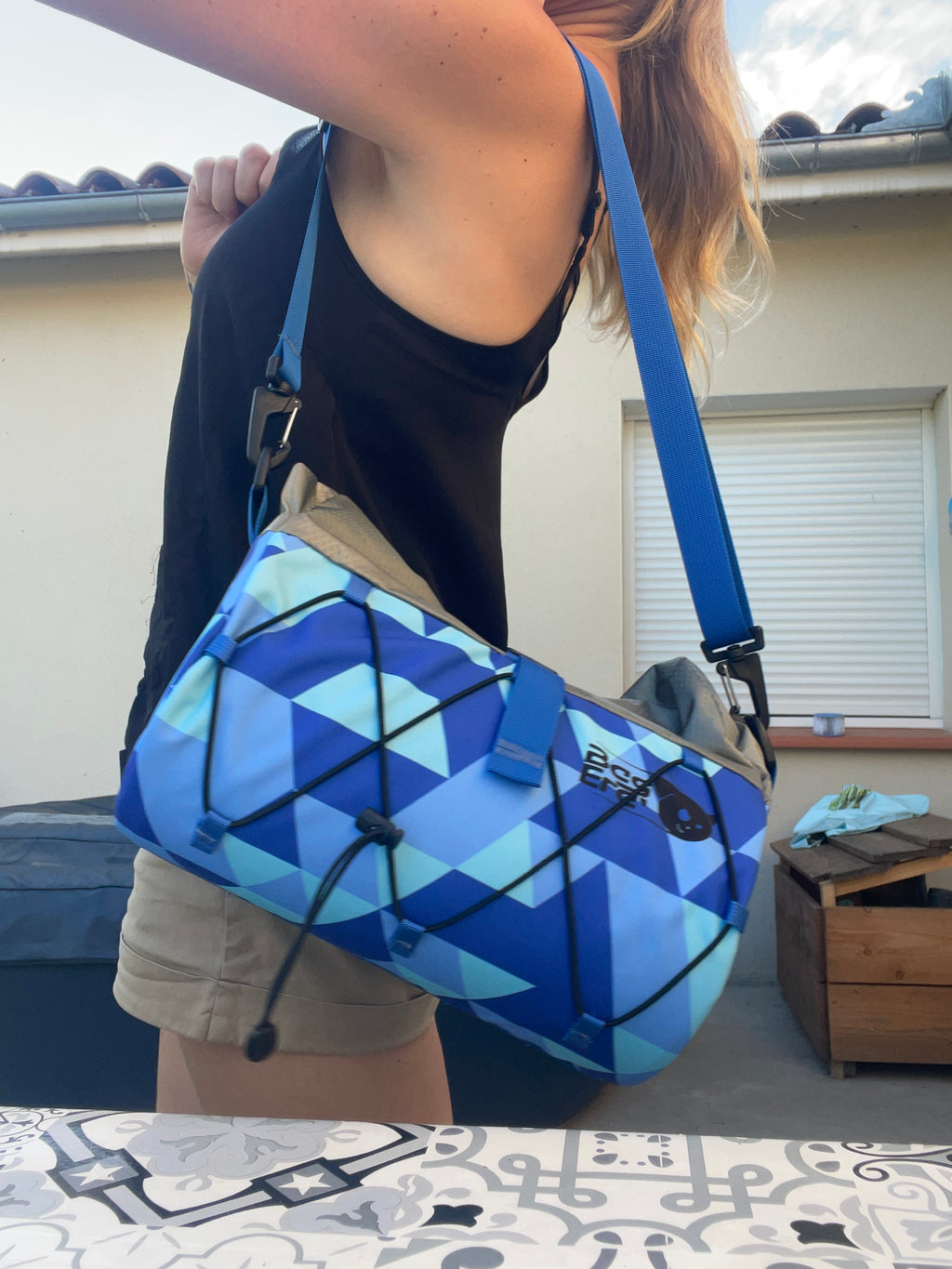 pochett de guidon, Fovea, avec triangle bleue, portée en bandoulière à l'épaule