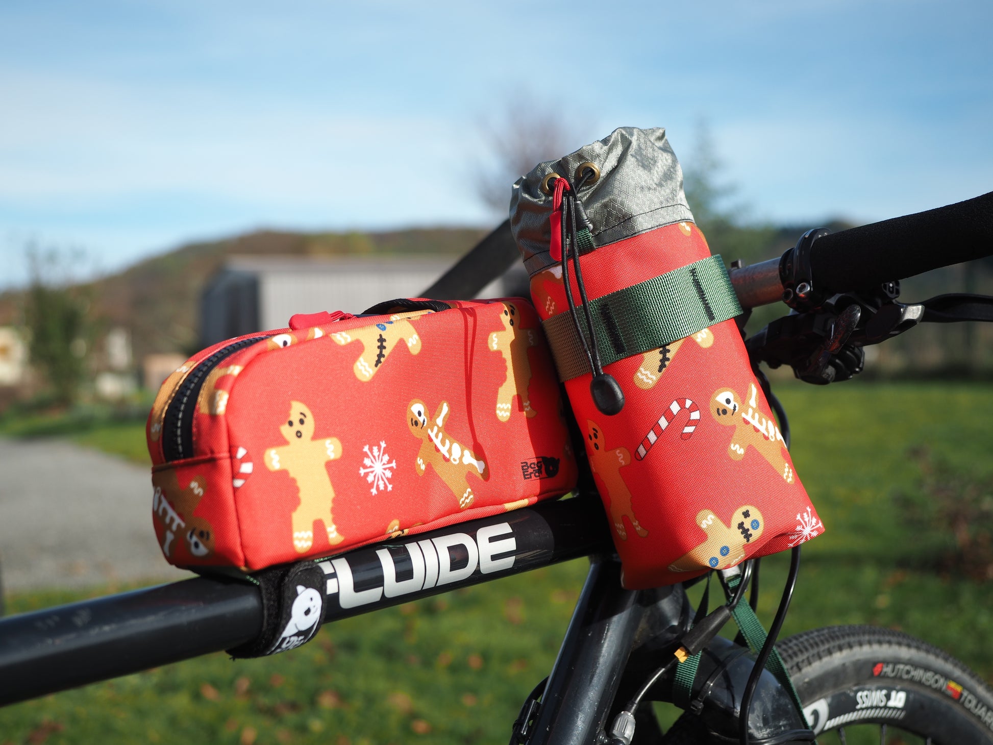 Photo des sacoches Rivus (sacoche de gourde) et Nutrix (sacoche top tube) avec motif Ginger Gang, équipée sur un vélo en exterieur