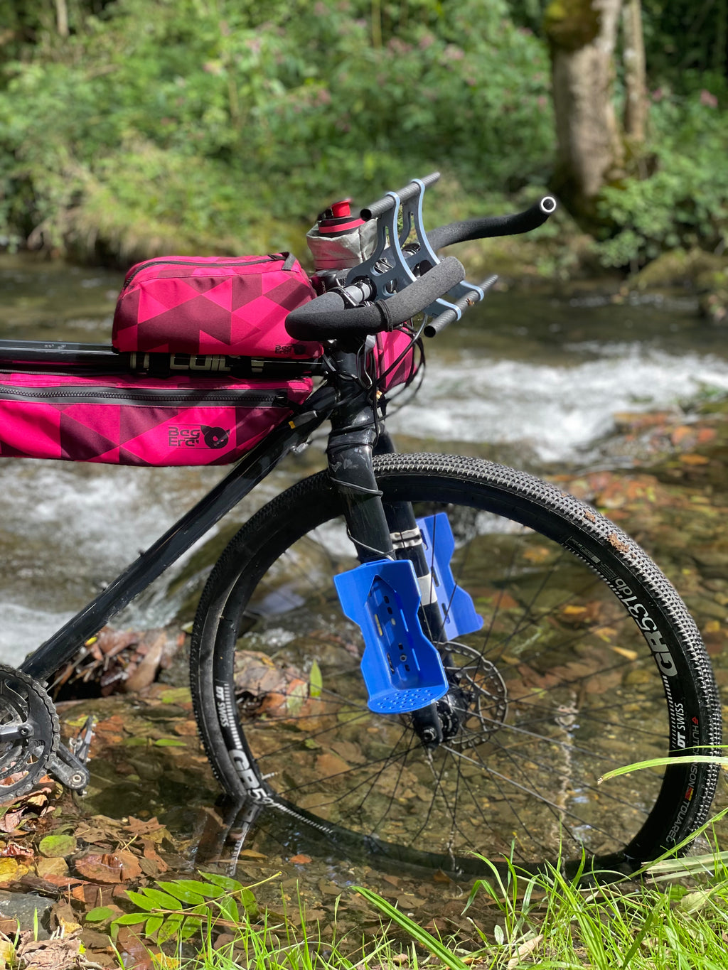 vélo équipé d'un set de sacoches avec le motif triangle accompagné d'une palette de différent déclinaisons de rose
